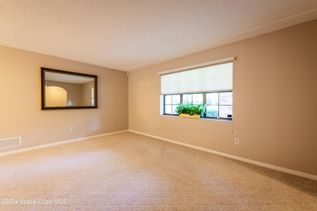 carpeted spare room featuring a textured ceiling