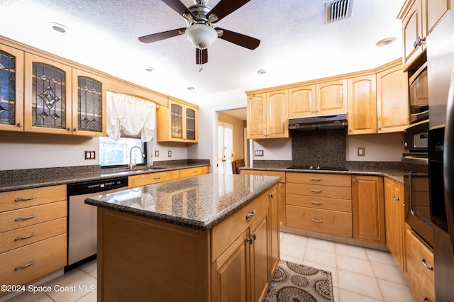 kitchen featuring light tile patterned flooring, a kitchen island, dark stone countertops, ceiling fan, and stainless steel appliances