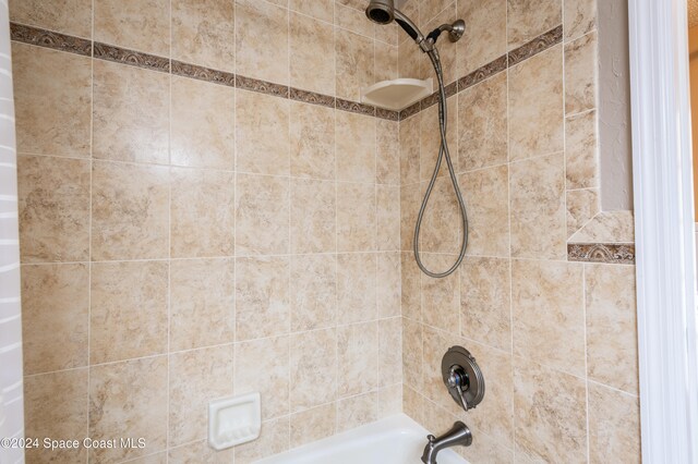 details featuring tiled shower / bath combo