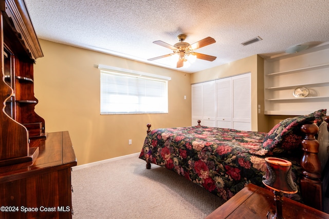 bedroom featuring ceiling fan, a closet, a textured ceiling, and carpet