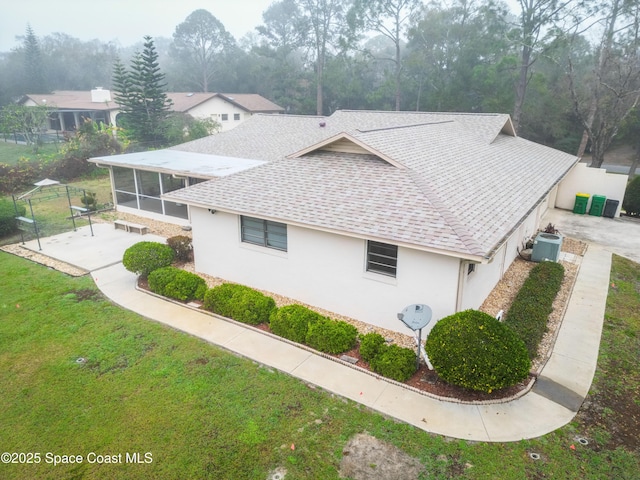 view of home's exterior with central AC unit, a yard, a sunroom, and a patio