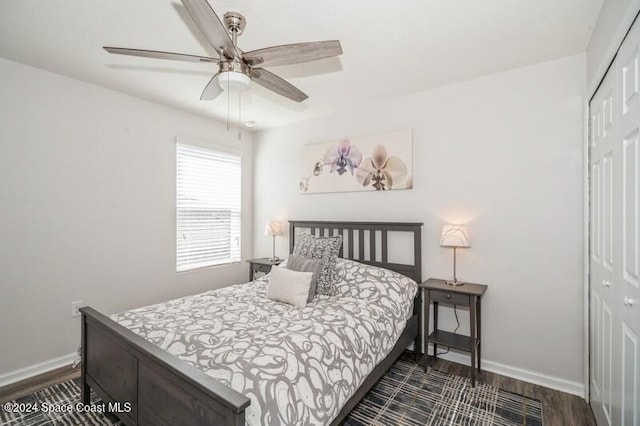 bedroom featuring a closet, baseboards, dark wood-style floors, and a ceiling fan