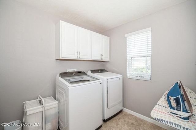 laundry room featuring baseboards, cabinet space, and independent washer and dryer