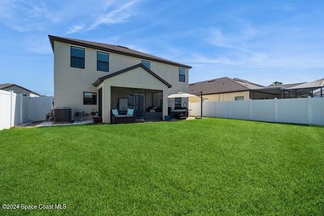 rear view of property featuring a yard, central AC unit, a fenced backyard, and stucco siding