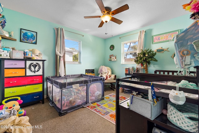 bedroom with a textured ceiling, carpet flooring, and ceiling fan