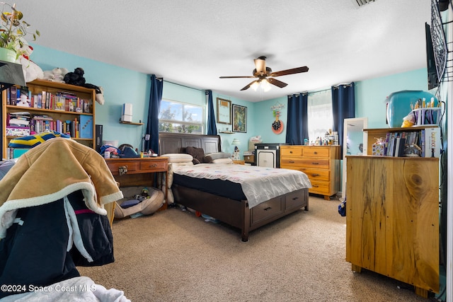 carpeted bedroom with a textured ceiling and ceiling fan