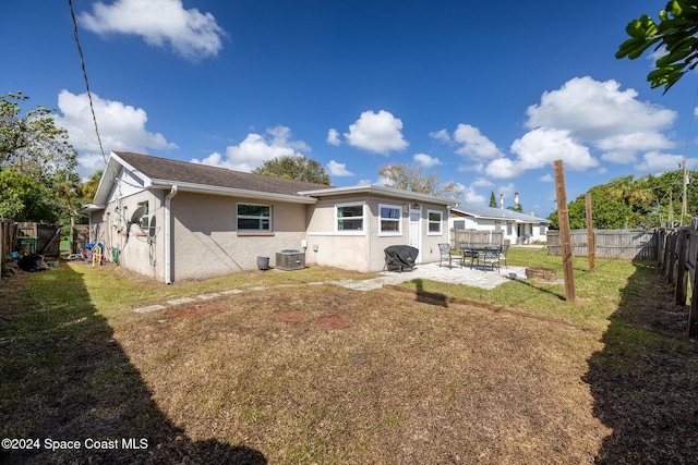 back of property with a patio area and a lawn