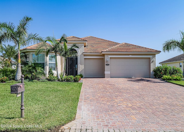 view of front of property with a front lawn and a garage