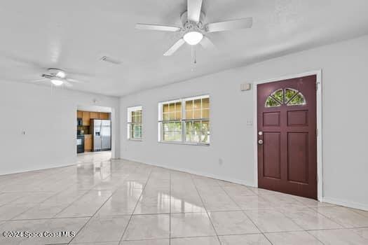 foyer with light tile patterned floors and ceiling fan