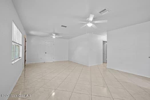 tiled empty room featuring ceiling fan