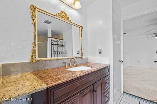 bathroom featuring tile patterned flooring, vanity, and ceiling fan