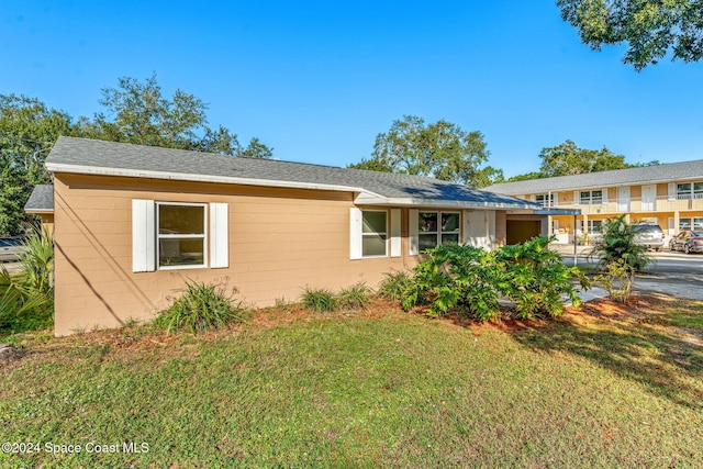 single story home featuring a front lawn