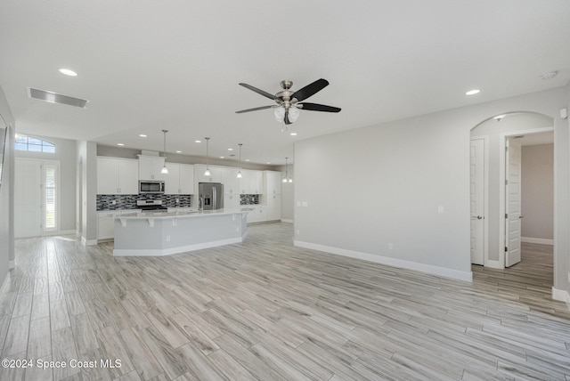 unfurnished living room featuring light hardwood / wood-style floors and ceiling fan