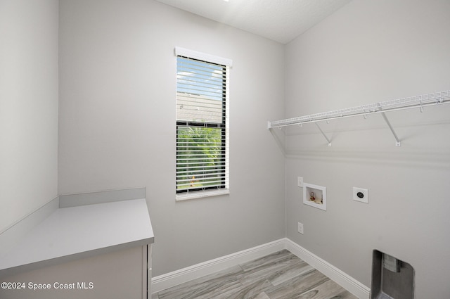 clothes washing area with washer hookup, hookup for an electric dryer, and light wood-type flooring