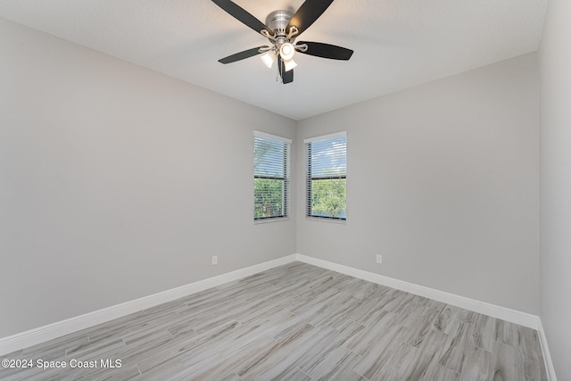 empty room featuring a textured ceiling, light hardwood / wood-style floors, and ceiling fan