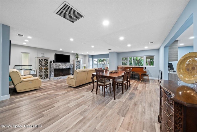 dining area featuring light hardwood / wood-style floors and a textured ceiling