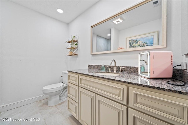 bathroom with tile patterned flooring, vanity, and toilet