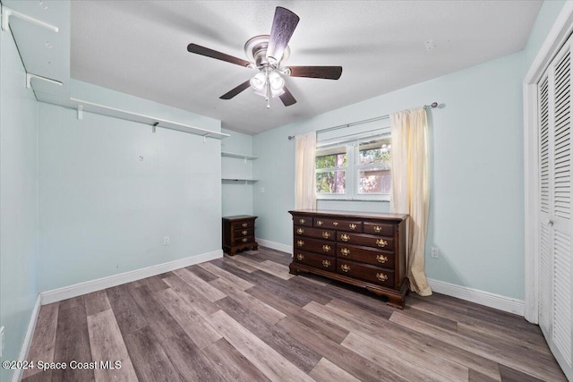 unfurnished bedroom featuring hardwood / wood-style flooring, ceiling fan, and a closet