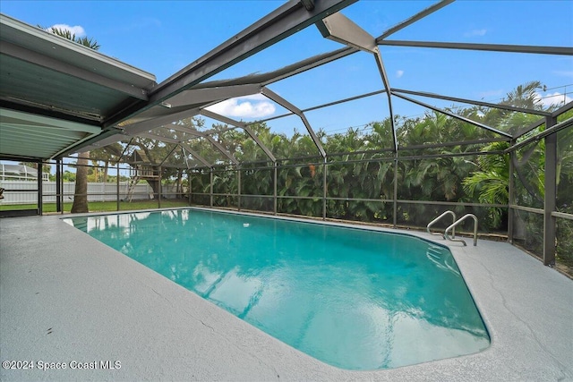 view of swimming pool with glass enclosure and a patio area