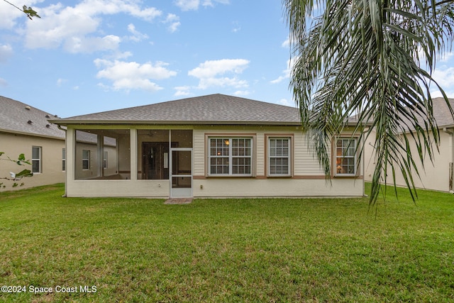 back of property with a lawn and a sunroom