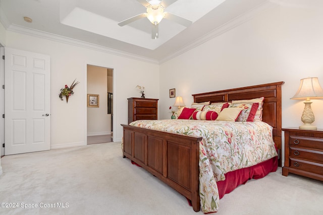 carpeted bedroom featuring ceiling fan, crown molding, and a tray ceiling