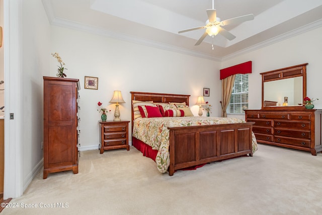 carpeted bedroom featuring crown molding, a raised ceiling, and ceiling fan