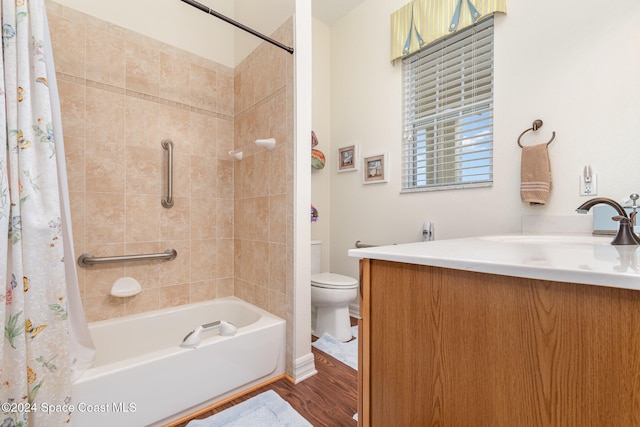 full bathroom featuring vanity, hardwood / wood-style floors, shower / bath combo with shower curtain, and toilet