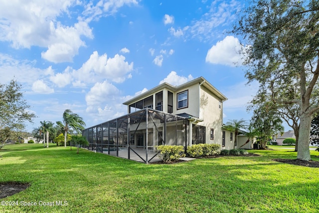 rear view of house featuring a lanai, a yard, and a patio