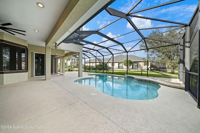 view of swimming pool with a lawn, ceiling fan, a patio area, and a lanai