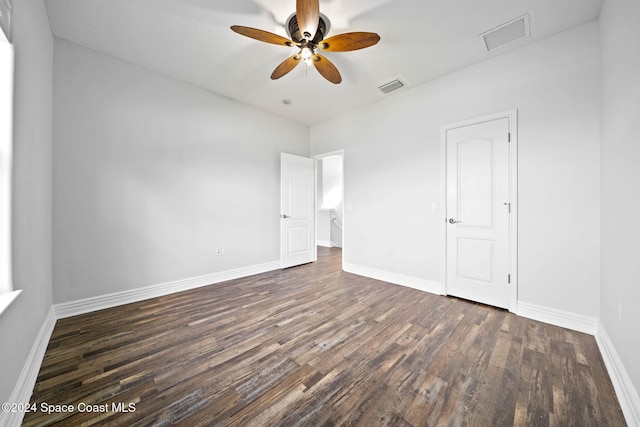 empty room with ceiling fan and dark hardwood / wood-style flooring