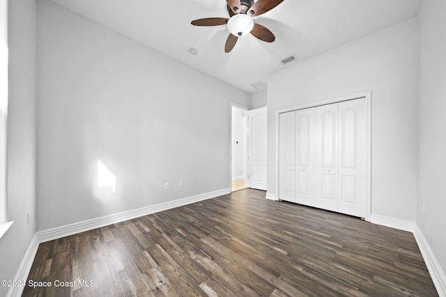 unfurnished bedroom with dark hardwood / wood-style floors, ceiling fan, and a closet