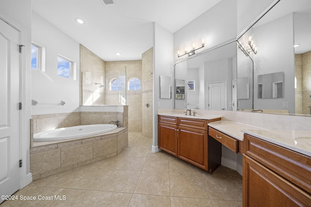 bathroom with plus walk in shower, vanity, and tile patterned flooring