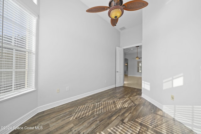 spare room featuring dark hardwood / wood-style flooring, high vaulted ceiling, ceiling fan, and a healthy amount of sunlight