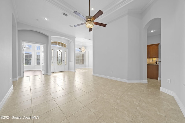 empty room featuring light tile patterned floors, ceiling fan with notable chandelier, and ornamental molding