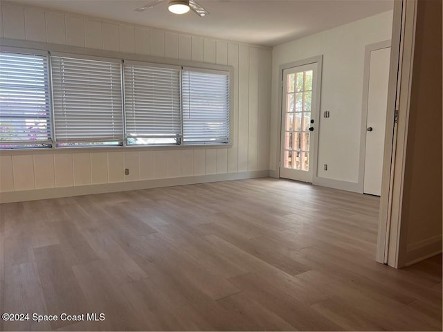 empty room with ceiling fan and light hardwood / wood-style flooring