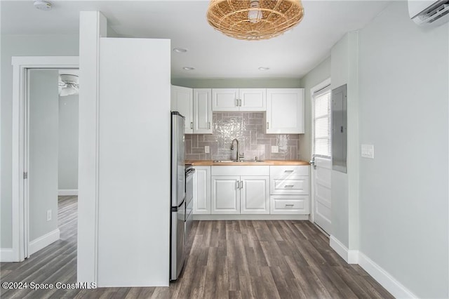 kitchen featuring wooden counters, dark hardwood / wood-style floors, backsplash, sink, and white cabinetry