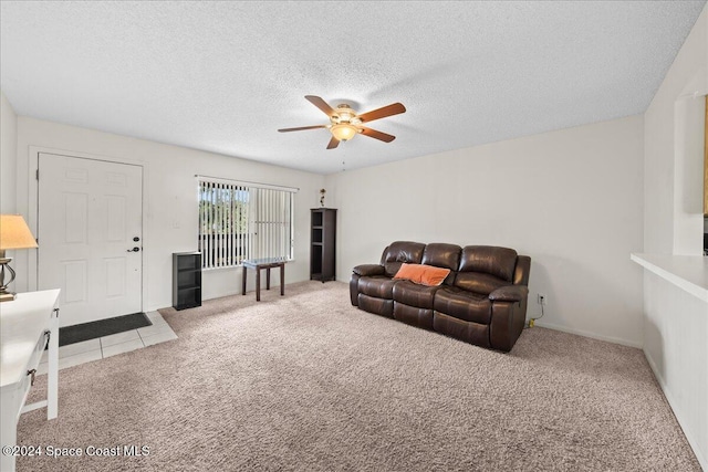 living room with a textured ceiling, ceiling fan, and light carpet