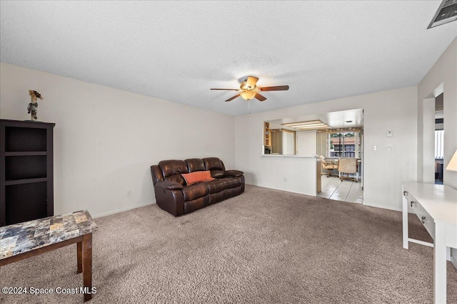 carpeted living room featuring a textured ceiling, a wealth of natural light, and ceiling fan