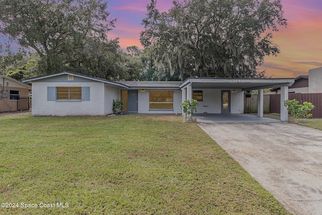 view of front of house with a yard and a carport