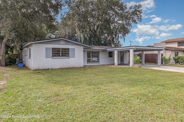 single story home featuring a front lawn and a carport