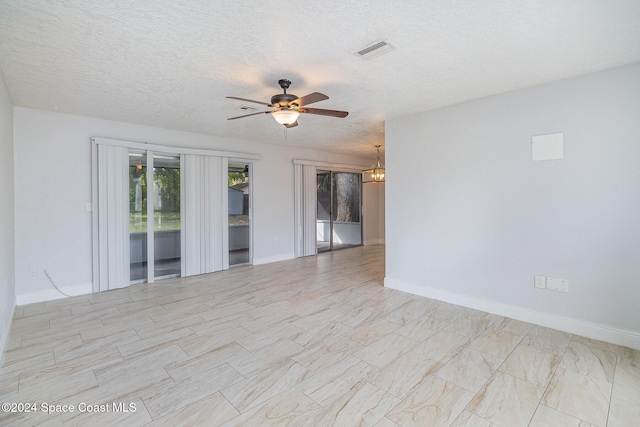 unfurnished room with a textured ceiling and ceiling fan with notable chandelier