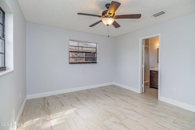 unfurnished room with a textured ceiling and ceiling fan