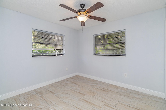 empty room with a textured ceiling and ceiling fan