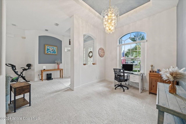 office with light carpet and an inviting chandelier