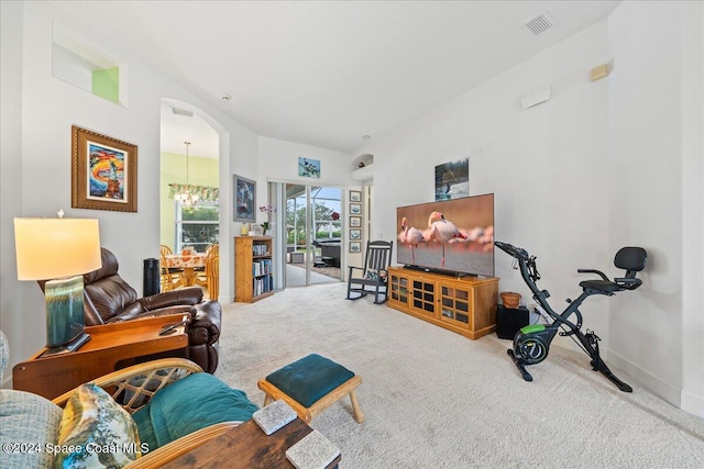 living room featuring an inviting chandelier and carpet floors