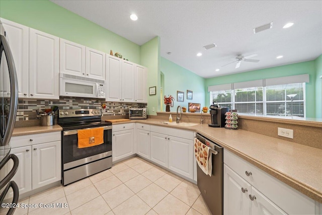 kitchen featuring white cabinetry, appliances with stainless steel finishes, sink, and ceiling fan