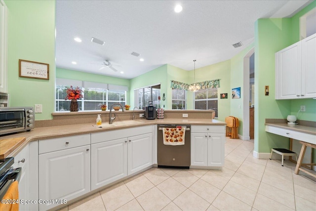 kitchen featuring stainless steel appliances, white cabinetry, pendant lighting, sink, and ceiling fan with notable chandelier