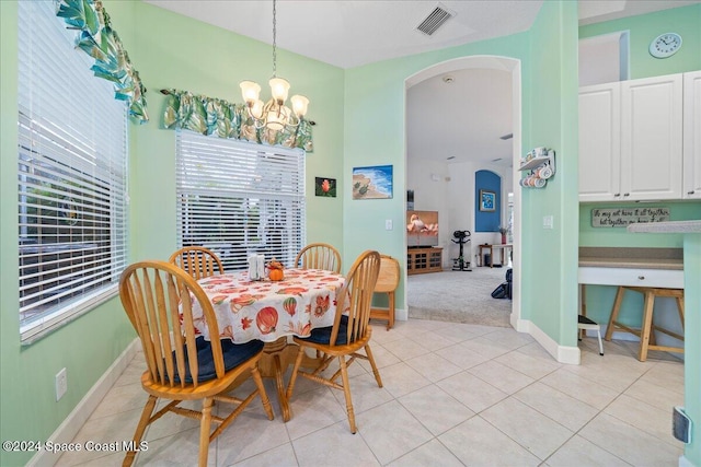 tiled dining room featuring an inviting chandelier