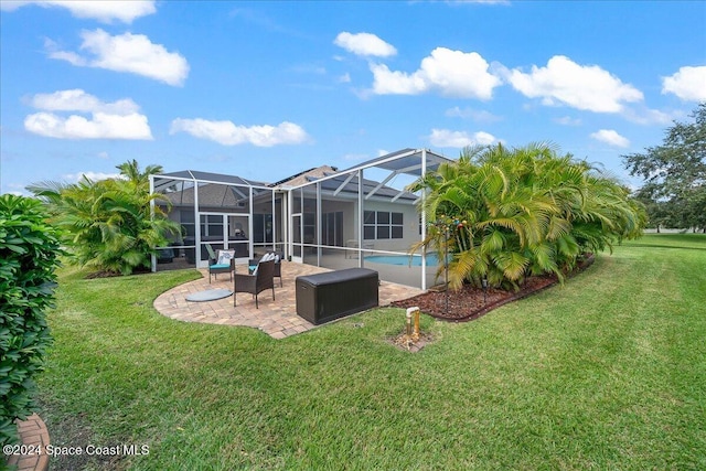 rear view of property with a lanai, a yard, and a patio area