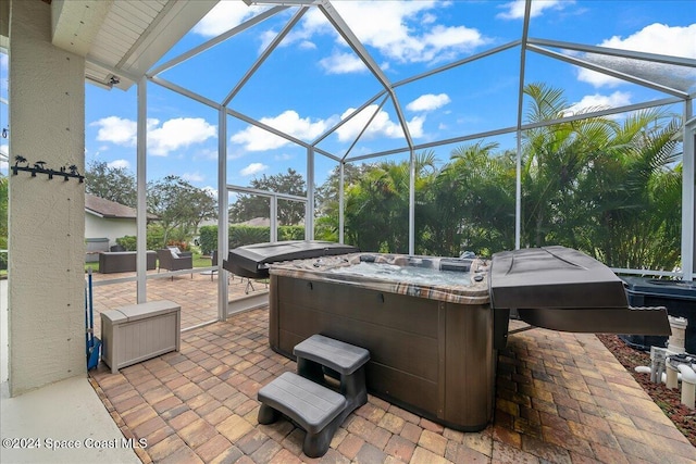 view of patio / terrace with a hot tub and glass enclosure